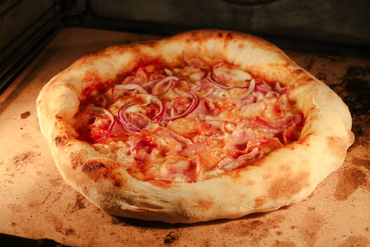 Pizza Prosciutto funghi auf Pizzastein